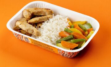 Iscas de filé de peito de frango com arroz branco e legumes salteados no az...